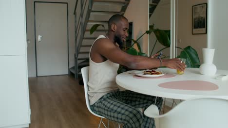 man having breakfast and using phone