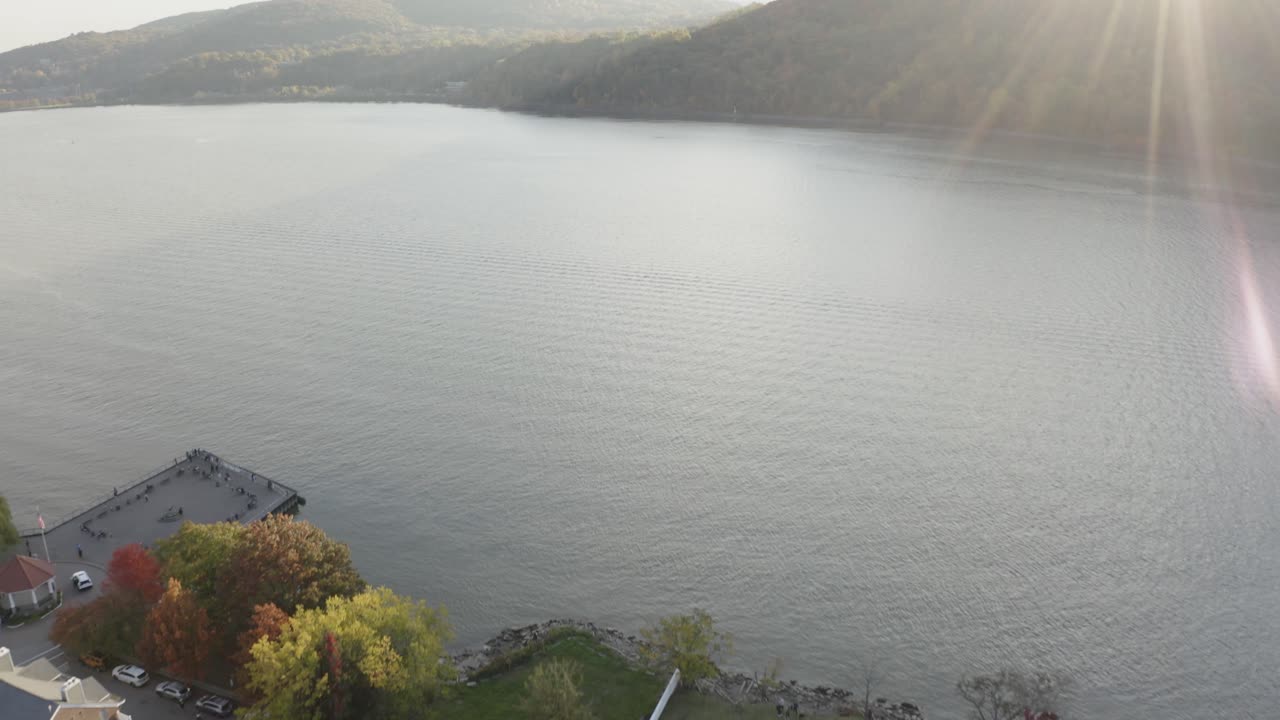 парк зеленой травы 4k орбитальный дрон панорамирование вверх, чтобы увидеть вспышку солнца над горой