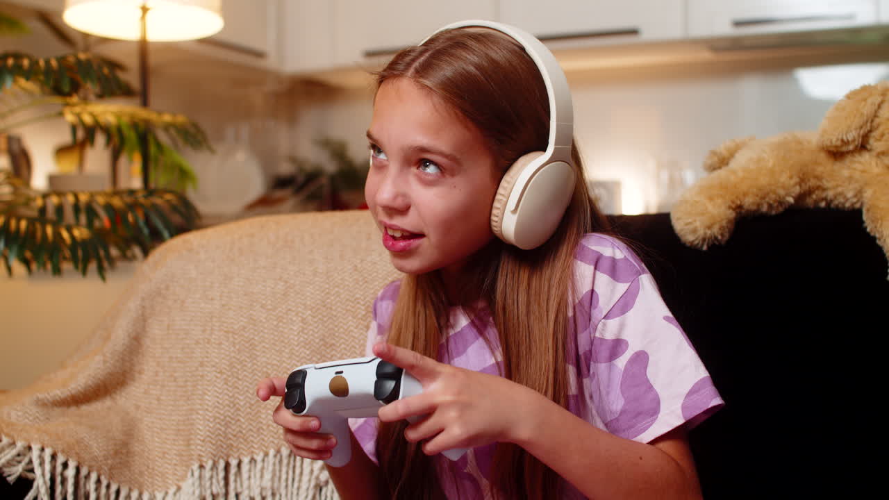 Teenager girl holds game controller plays console game intense focus emotion enjoys evening time fun