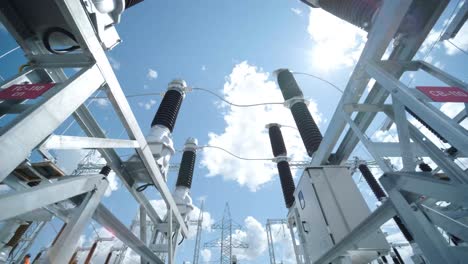 many high voltage electrical insulators in power substation against blue sky background