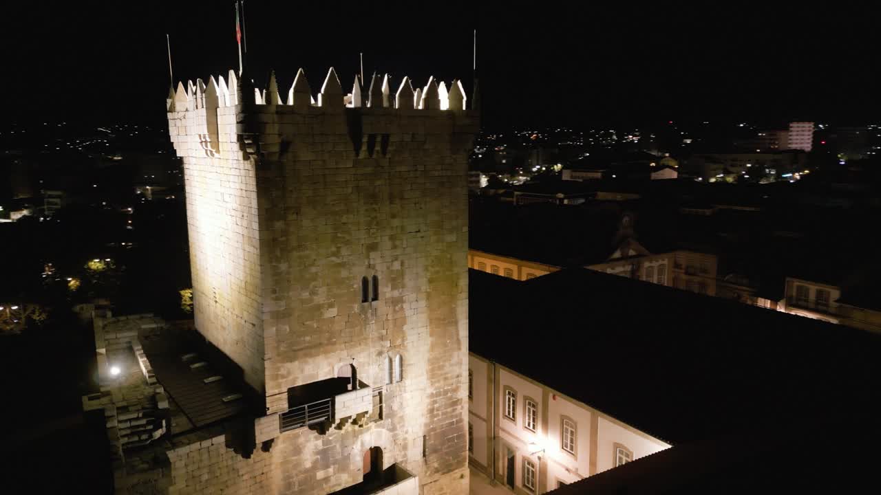 drones orbitan alrededor de la torre del castillo iluminada por la noche en chaves vila real portugal