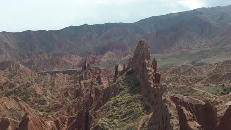 aerial pullback from towering rock spires in fairytale canyon skazka, kyrgyzstan, highlighting the canyon's dramatic landscape