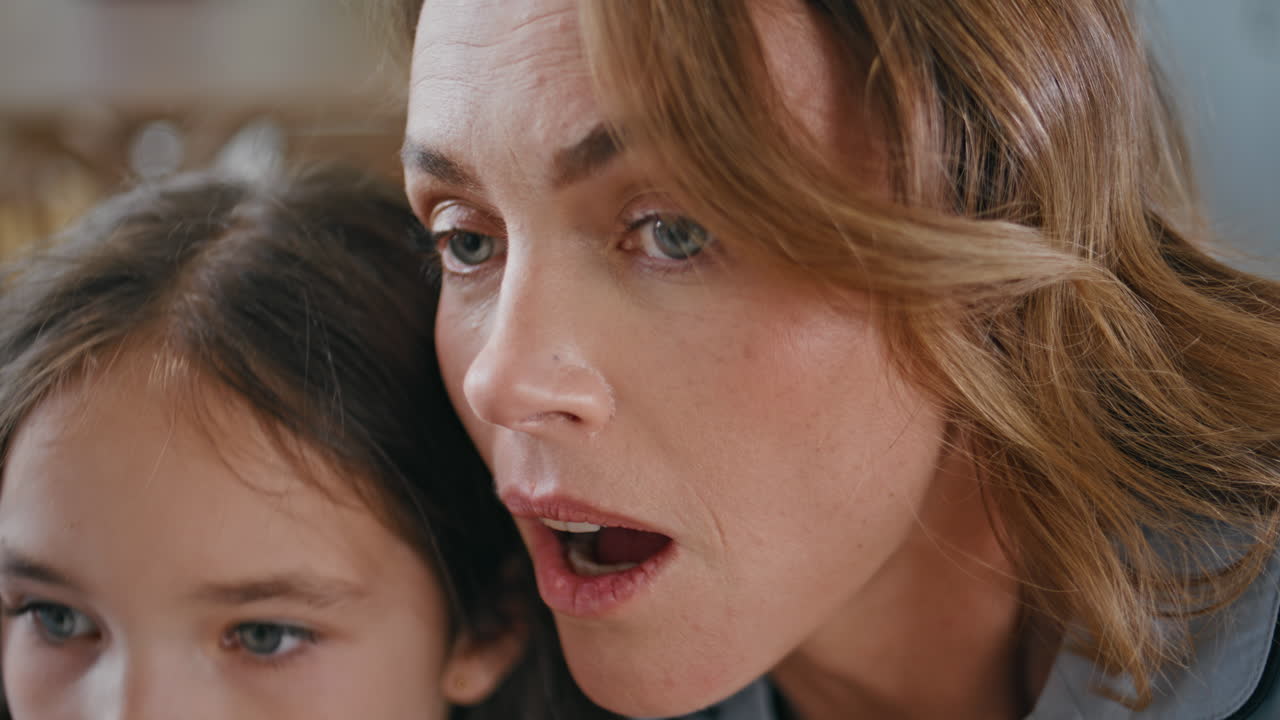 Surprised lady embracing daughter at apartment closeup. Shocked woman reacting