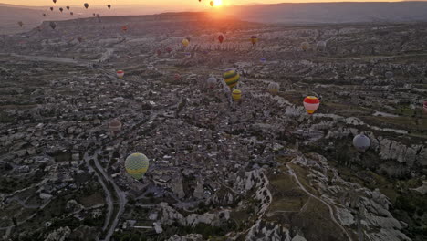 Göreme-Turquía-Aérea-V51-Vista-De-Pájaro-Que-Captura-El-Terreno-Rocoso-Y-La-Antigua-Ciudad-Desde-Arriba-Con-Coloridos-Globos-Aerostáticos-En-Lo-Alto-Del-Cielo-Al-Amanecer---Filmada-Con-Mavic-3-Cine---Julio-De-2022