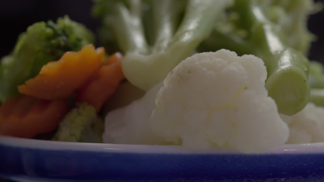 Fresh vegetables on a blue plate, healthy meal concept, close-up