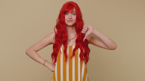 upset woman in tank top showing thumbs down sign gesture, disapproval, dissatisfied dislike