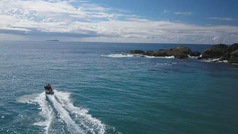 People-on-motorboat-navigating-along-Emerald-beach,-Australia