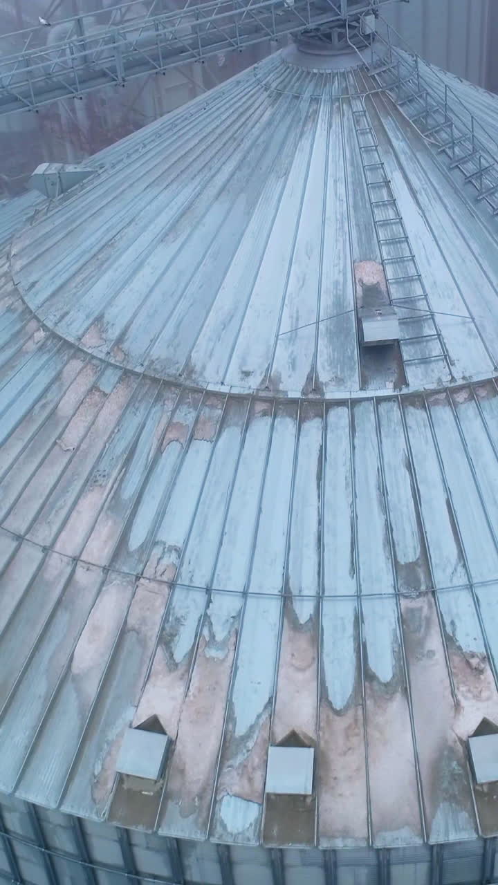 Big industrial elevator metal construction. Huge harvesting grain tanks. Vertical video