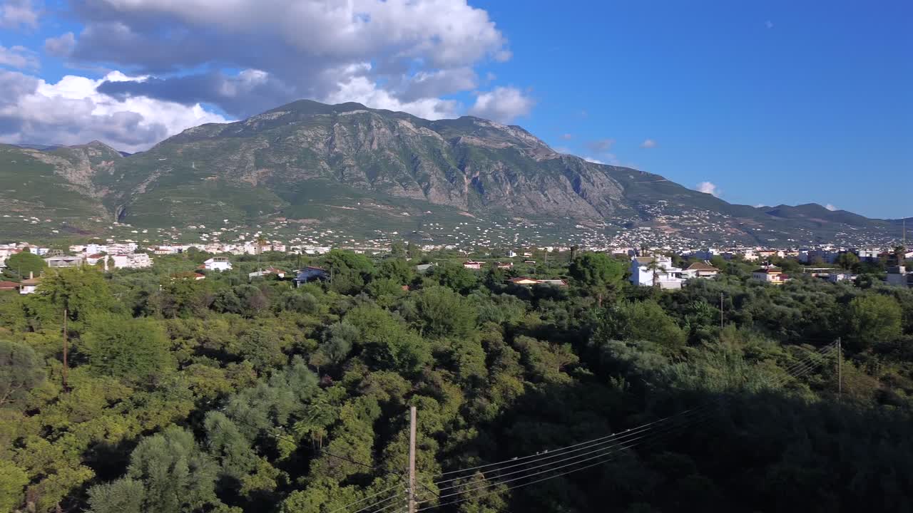 Aerial wide panoramic view of Taygetos mountain, Peloponnese , Greece. Left slide and pan, raise up drone movement , flying over olive tree orchards 4K