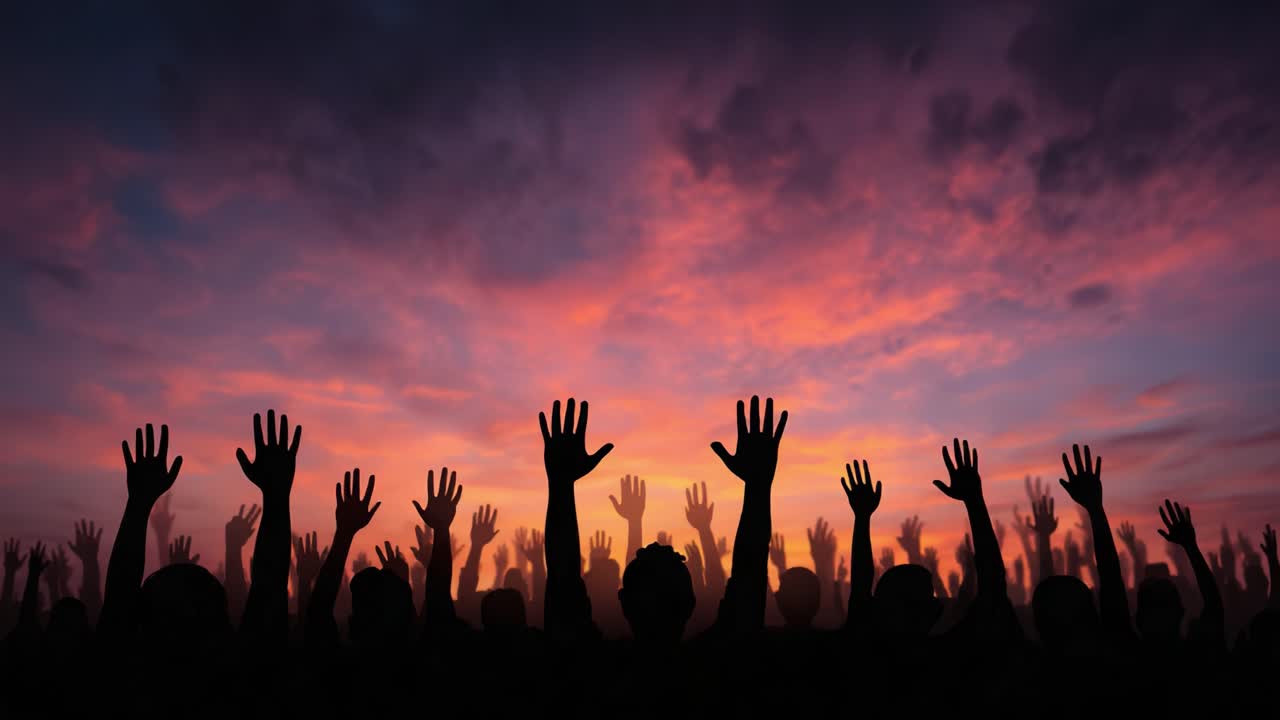Silhouetted Hands Raised Against a Vibrant Sunset Sky – A Symbol of Unity and Collective Expression as People Celebrate Together in a Colorful Twilight Atmosphere