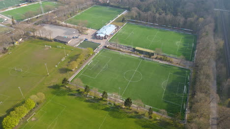Aerial-of-green-soccer-fields---drone-flying-backwards