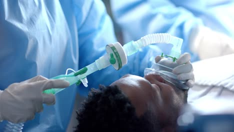 diverse surgeons giving anesthesia to patient in operating theatre, slow motion