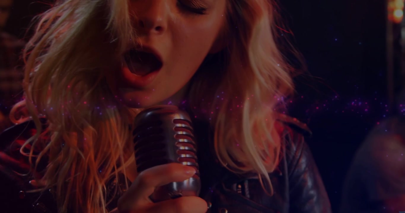 Lead singer leaning into retro mic singing for music club while pink particles swirling around her