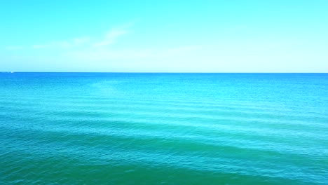 Look-at-this-perfect-blue-waves-in-Florida-ocean,-bright-blue-background,-cinematic-shot