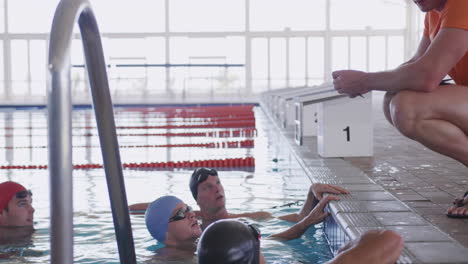 swimming coach talking to swimmers