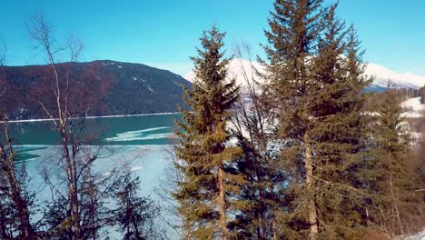 4k drone video of snow covered lakeside mountains in alaska during winter