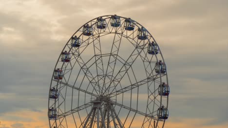 timelapse of rotating ferris wheel and clouds movement, sunset cloudy sky