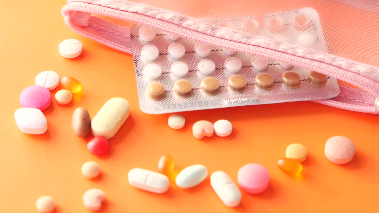 분홍색 가방에 여러 가지 약과 태블릿이 들어 있습니다.