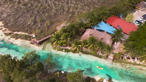 Oribital-drone-shot-of-kayakers-paddling-through-the-famous-"los-rapidos"-rapids-canal-located-in-Bacalar,-Mexico-shot-in-4k