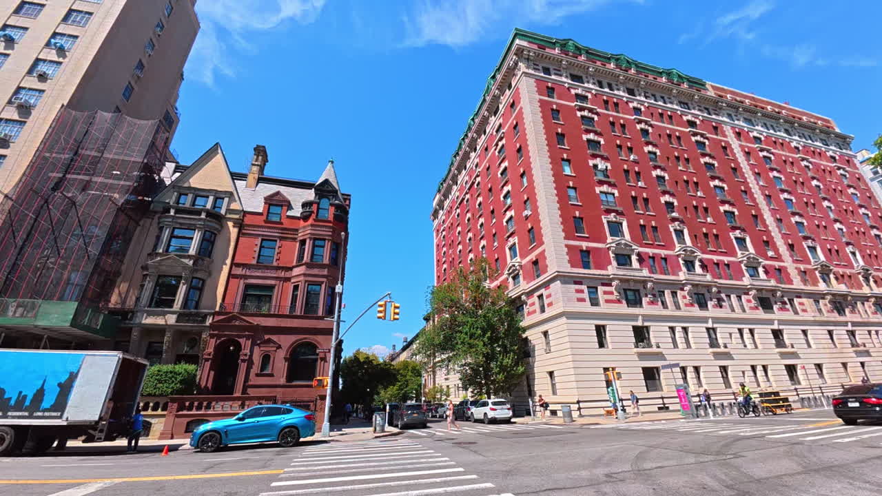 Nowy Jork, USA, 1 sierpnia 2025: Historyczne i nowoczesne budynki na ulicy Manhattanu. Połączenie zabytkowych budynków z cegły i nowoczesnej architektury na Manhattanie z samochodami zaparkowanymi wzdłuż ulicy.
