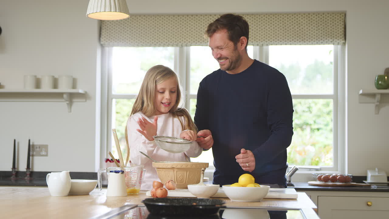 Vater und Tochter backen gemeinsam in der Küche zu Hause.