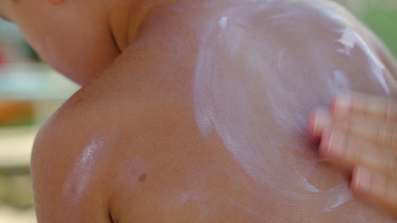 madre aplicando protector solar en la piel de sus hijos