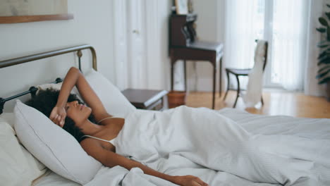 Drowsy-model-falling-pillow-early-morning.-Black-hair-woman-awake-after-insomnia