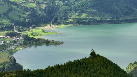 aerial telephoto view of village on volcanic crater lake shore, sete cidades