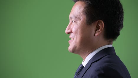 mature japanese businessman against green background