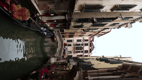 vertical - narrow river canal in famous touristic city of venice, italy