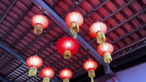 Encantadores-Farolillos-Rojos-Decorando-Un-Edificio-Tradicional-De-Singapur,-Toma-De-ángulo-Bajo