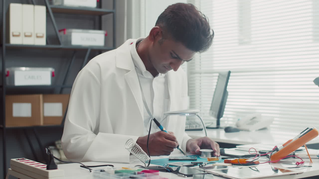 Repairman Reassembling Broken Smartphone at Service Center