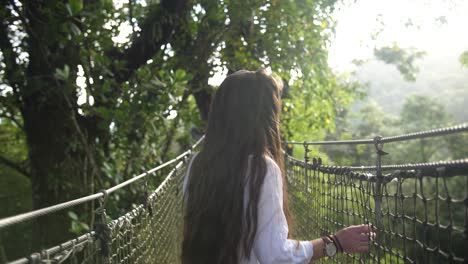 Hermosa-Mujer-Avanzando-Sobre-Un-Puente-Peatonal-En-La-Cima-De-Un-árbol-Y-Sonriendo