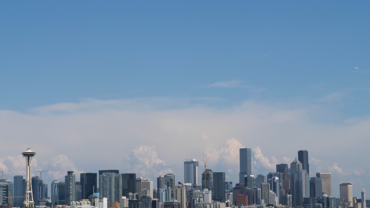 Airliner flying over Seattle.City skyline, viewed from Elliott Bay, Seattle, Washington.