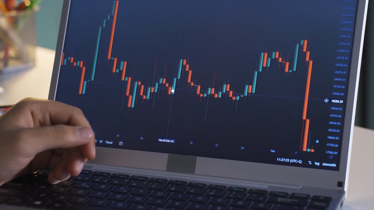 hombre siguiendo de cerca el mercado de valores y los gráficos de criptomonedas en la computadora portátil.