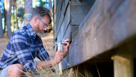 man hammering wooden plank with hammer 4k