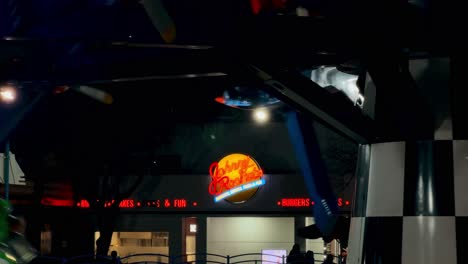 establishing with the isolated johnny rockets sign illuminated at night, at the fantasilandia amusement park in santiago, chile.