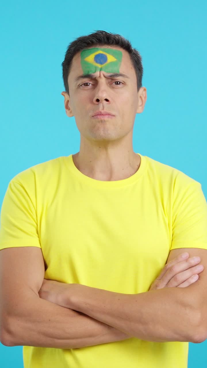 Dignified and serious man with brazilian flag painted on face