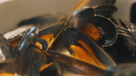 cooked hot mussels lying in bowl with white wine sauce ready to be eaten. delicious seafood mollusk shellfish meal