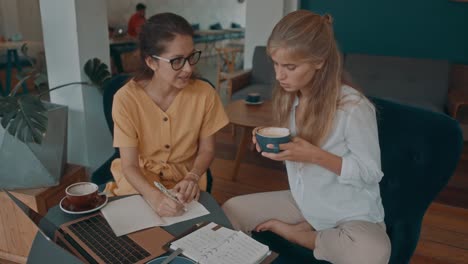 mujeres de negocios se reúnen en un café.