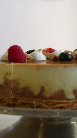 close-up of delicious caramel cake with berries and whipped cream