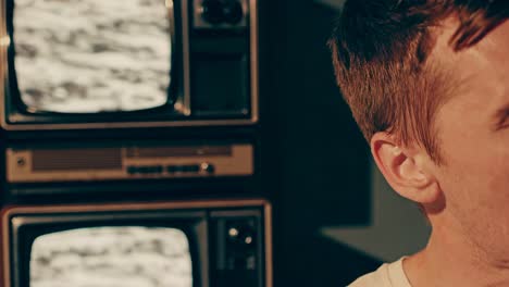 hombre estresado frente a viejos televisores