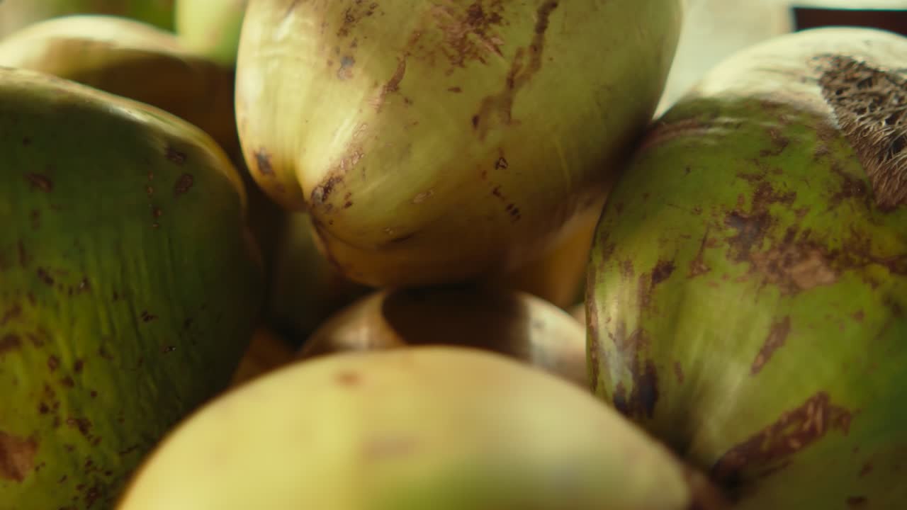 Primo piano di noci di cocco verdi fresche impilate insieme, che evidenzia la texture naturale, il cibo tropicale e i dettagli organici della superficie