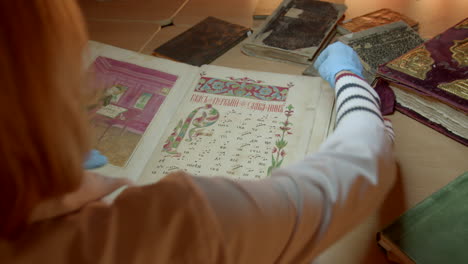 archivist examining an illuminated manuscript