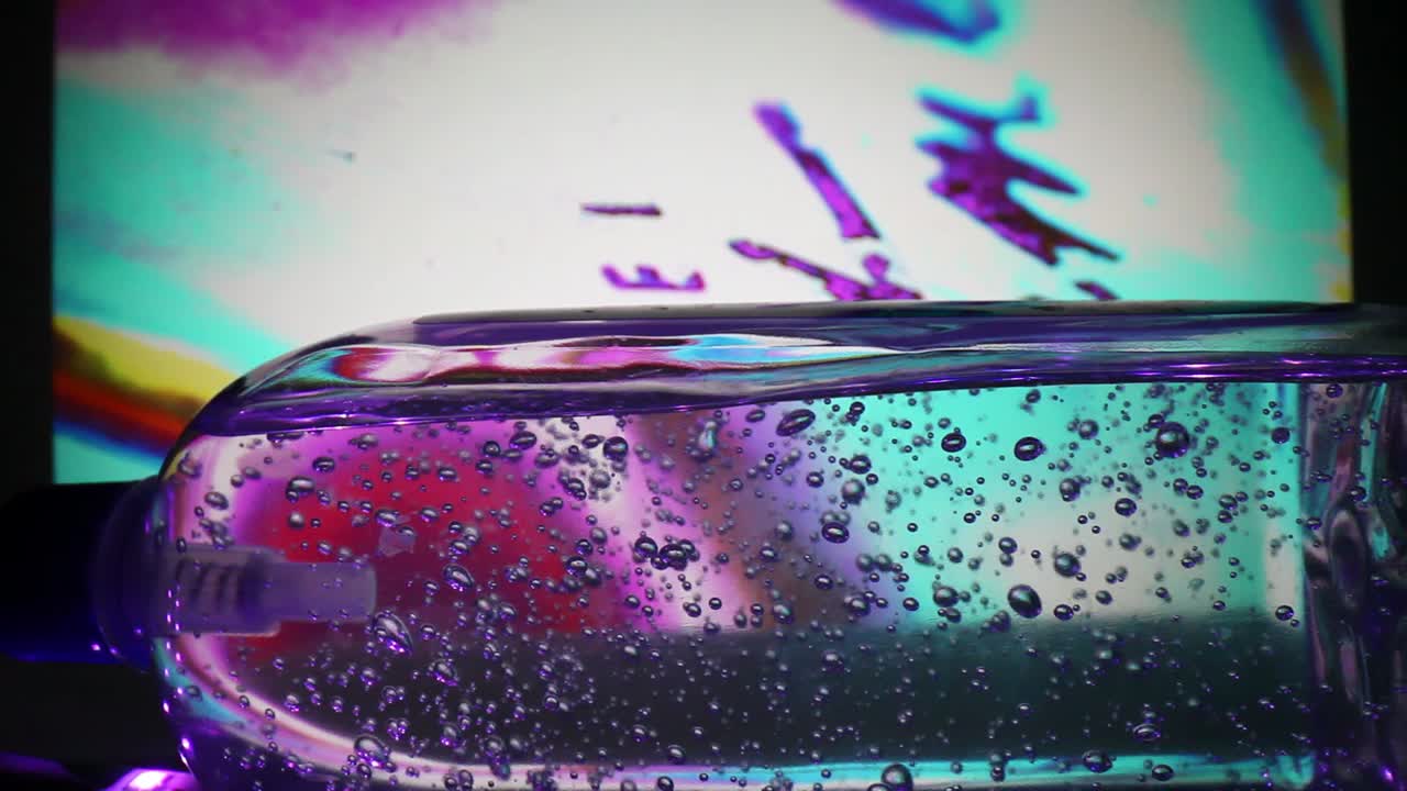 alejándose de una botella grande de desinfectante para manos ya que el fondo es muy colorido - cambiando