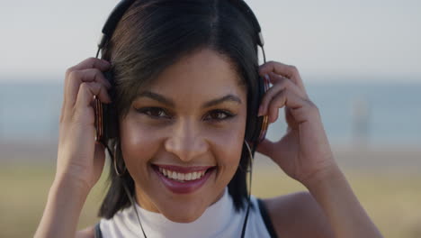 portrait lively young hispanic woman takes off headphones enjoying relaxed summer day listening to music slow motion