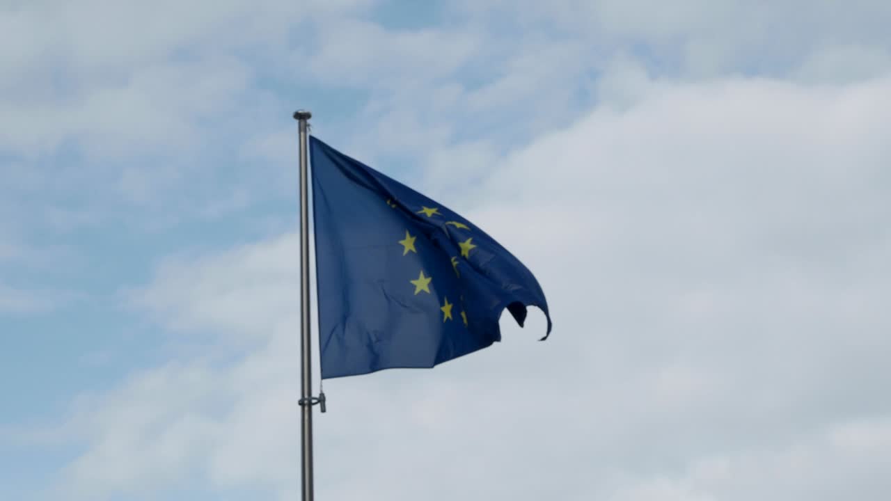 primer plano de la bandera de la ue o de la unión europea en movimiento contra el cielo azul
