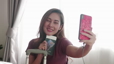 Woman-happy-selfie-portrait-with-her-passport-and-credit-card-before-travel-trip