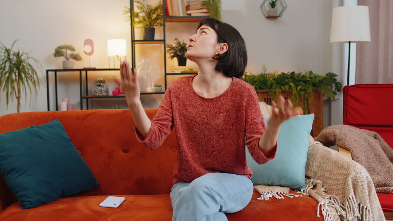Irritated woman girl covers ears with cushions annoyed by noisy neighbors suffers from headache
