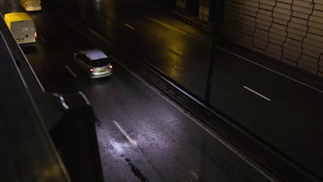 Cars-seen-from-above-at-night-driving-on-motorway-in-Shepherd's-Bush,-London,-UK